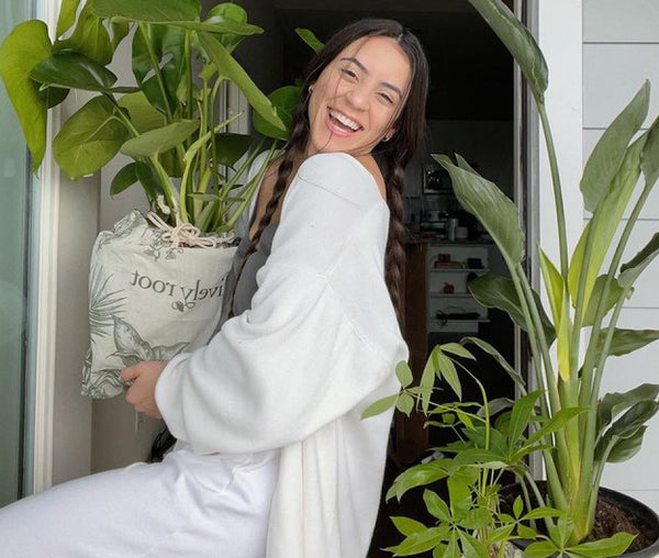 Smiling lady dressed in white with plants
